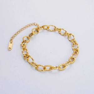Detailed close-up of 18K gold-plated Cuban chain link bracelet with lobster clasp and tag