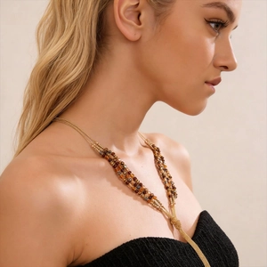 Detail of Bohemian triple-layer tassel sweater necklace with amber glass beads and gold chains