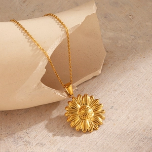18K gold plated stainless steel sunflower pendant necklace on beige stone display