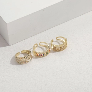 Three-piece gold-plated open rings with colorful zircon and pearls on white geometric blocks