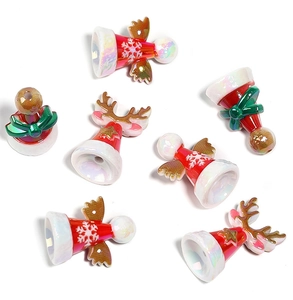 Macro detail of Christmas beads featuring pearlized reindeer and angel charms for DIY jewelry