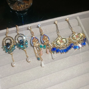 Vue détaillée de boucles d'oreilles ethniques dorées avec cristaux et perles