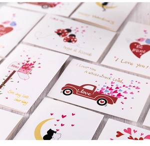 Various Valentine cards with gold stamping on wooden surface, including hugs & kisses designs