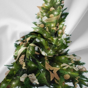 Dettaglio del tessuto morbido con albero di Natale verde, stelle dorate e fiocchi bianchi