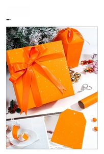 Detail of orange glitter gift boxes with gold foil wrapping paper and festive ribbons