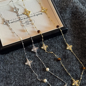 Collier perles vintage avec croix et pierre œil de tigre sur fond en maille douce