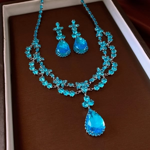 Détails d'une parure de bijoux avec goutte de zircon bleu dans son écrin de luxe