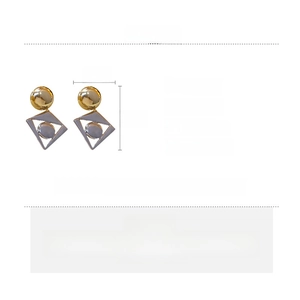 Detail view of geometric drop earrings with gold ball and silver-tone diamond shape