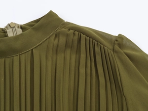 Close-up of green pleated chiffon dress showing stand collar and back zipper detail