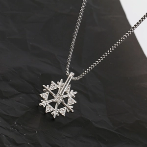Rotating snowflake necklace in titanium steel with sparkling crystals on black background