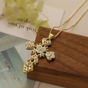 Detail of gold-plated cross necklace with pink heart gemstone and sparkling cubic zirconia