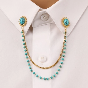 Detail of turquoise stainless steel collar pin with double chains on white shirt