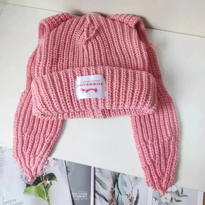 Detailed view of pink knitted cat ear beanie with signature brand logo label