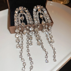 Close-up of luxury long tassel earrings with sparkling rhinestones on jewelry box