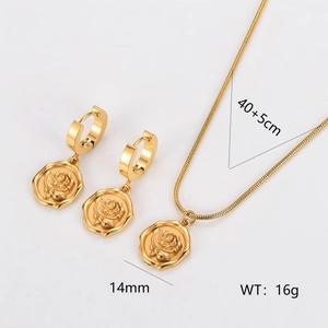 Golden stainless steel jewelry set with rose pendant necklace and earrings on white background