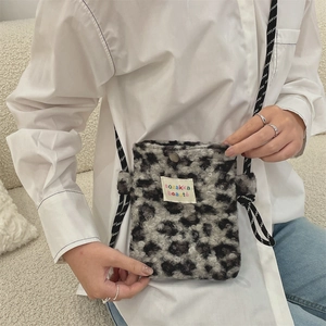 Détail du petit sac à bandoulière en peluche léopard gris avec une sangle stylée