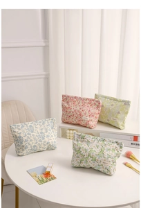 Detailed close-up of floral fabric makeup bags with zippers and elegant brand labels