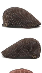 Détail de la casquette classique à rayures avec boucle métallique en bronze et tissu texturé