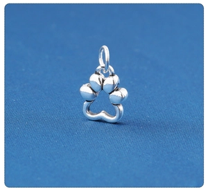 Macro shot of S925 sterling silver hollow cat paw pendant on blue fabric background