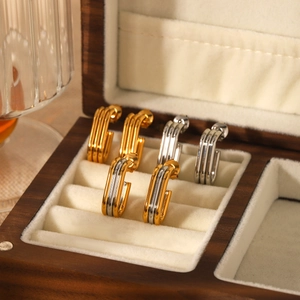 Elegant 18K gold and silver multi-layer stainless steel earrings on a jewelry box