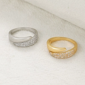 Detailed view of silver and gold wrap-around rings with sparkling cubic zirconia inlays