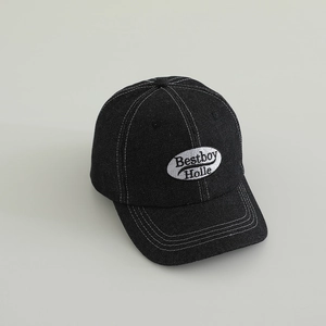 Detailed close-up of black denim fabric and Bestboy Holle embroidered patch on baseball cap