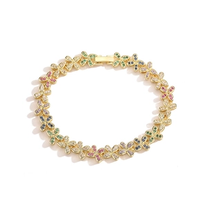 Close-up of gold bow bracelet with colorful cubic zirconia stones on white background
