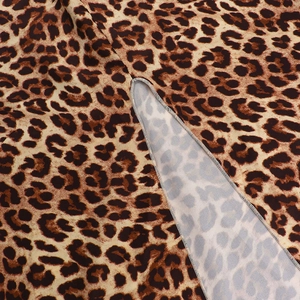 Detailed macro view of leopard print fabric featuring high-quality overlock stitching edge