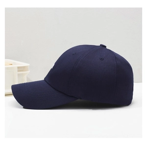 Side view of dark blue cotton baseball cap with ventilation holes and premium stitching
