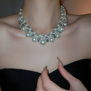 Detail of layered pearl choker necklace featuring sparkling rhinestones on an elegant model