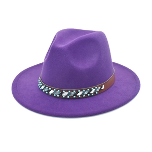 Détail du chapeau fedora violet en laine avec ruban perlé et large bord plat pour femme