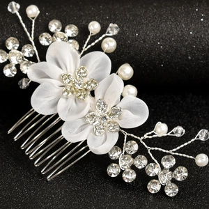 Detailed close-up of bridal hair comb with silk flowers and sparkling rhinestones
