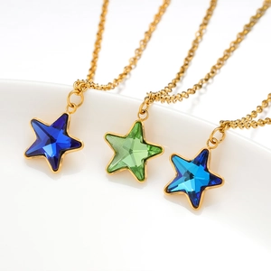 Detailed view of three gold necklaces with star-shaped gems in blue and green