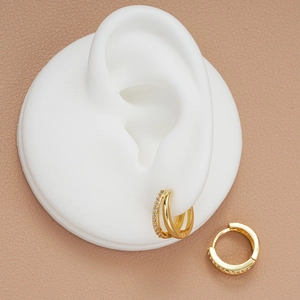 Double-layered gold geometric hoop earrings with sparkling cubic zirconia on model
