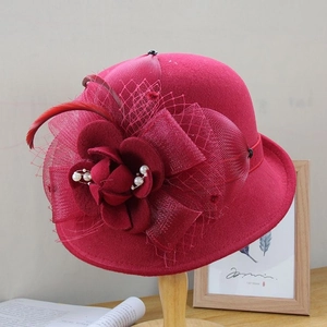 Détails d'un chapeau en feutre rouge avec fleurs, plumes et perles élégantes