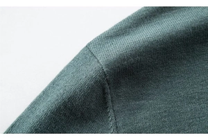 Makroaufnahme der feinen dunkelgrünen Strickstruktur und hochwertigen Nahtdetails