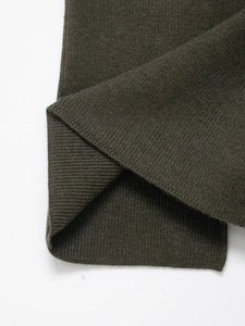Dettaglio della trama in maglia verde oliva scuro con elegante motivo a rombi intrecciati