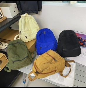 Detailansicht von Vintage-Canvas-Rucksäcken in Gelb, Blau, Schwarz, Grün und Braun