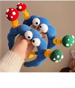 Close-up of funny blue plush headbands with cartoon mushroom springs and big eyes