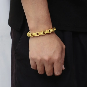 Close-up of men's 18k gold-plated titanium steel bracelet with hammered texture finish