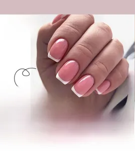 Detail of pink gradient press-on nails with classic white French tips in glossy finish