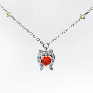 Detail of red circular gemstone pendant with blue and white accents on a silver chain