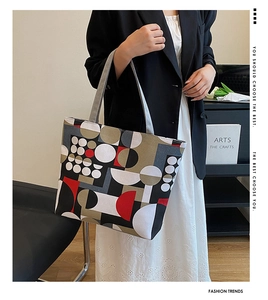 Canvas tote bag with geometric pop art pattern worn by a model in a stylish indoor setting