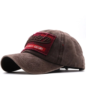 Dettaglio del cappellino vintage marrone con ricamo rosso e trama in tela di cotone lavato