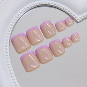 French tip press-on toenails in soft lavender and nude pink on a heart-shaped mirror