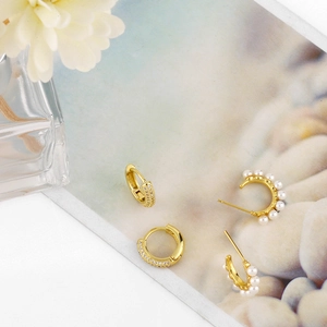 Elegant gold-plated C-shaped earrings set with white pearls and sparkling cubic zirconia