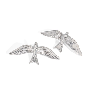 Détails macro d'un ensemble de bijoux hirondelle en argent avec textures d'ailes