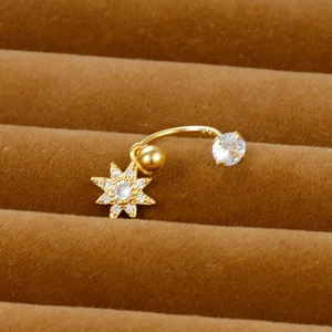 Detailed shot of golden belly ring with star pendant on brown velvet cushion