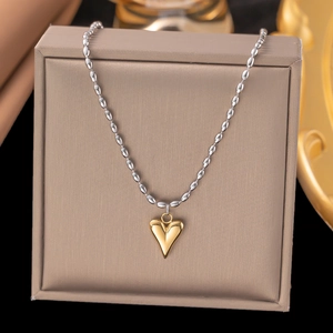 Elegant gold heart pendant with silver bead chain shown on a luxury jewelry gift box