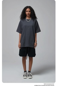 Full view of oversized dark grey cotton t-shirt with dropped shoulders and retro text